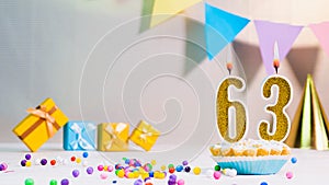 Happy birthday card from candles with the number 63, golden numbers from candles for congratulations on any holiday with beautiful