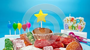 Happy birthday card, festive cupcake with birthday decorations on blue background
