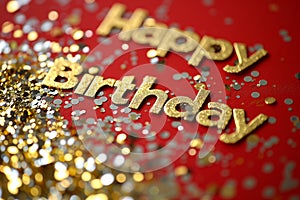 Happy Birthday card. Gold inscription Happy Birthday on red background with golden glitters
