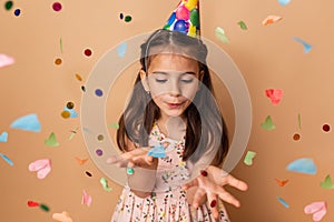 Happy birthday child girl with confetti on beige background