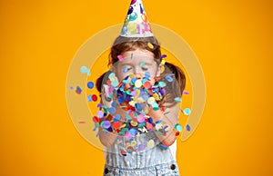 Happy birthday child girl with confetti on yellow background