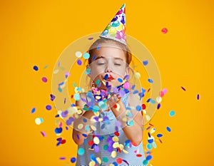 Happy birthday child girl with confetti on yellow background