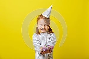 Happy birthday child girl holding confetti in hands