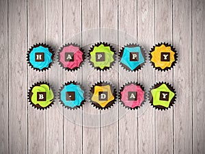 Happy Birthday cupcakes isolated on wood floor background