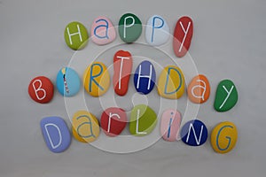 Happy Birthday Darling with colored stones over white sand