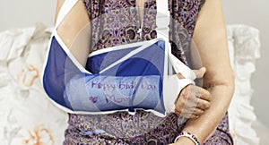 Happy birthday elderly woman with a broken arm.