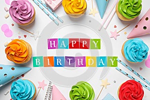 Happy Birthday. Flat lay composition with colorful cupcakes on white background