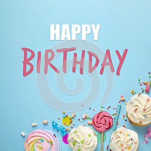 Happy Birthday! Flat lay composition with cupcakes on light blue background