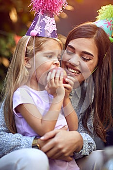 Birthday girl  celebrate birthday and  eating apple with her mother