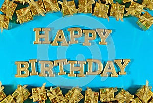 Happy birthday golden text and golden gifts on a blue