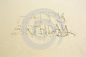 Happy birthday hand written message on wet beach sand