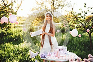 Happy birthday little girl with pink decor in beautiful garden.