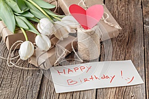 Happy birthday mesage with flowers on rustic table with flowers