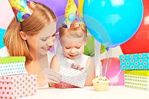 Happy birthday. mother giving gift to his little daughter with balloons