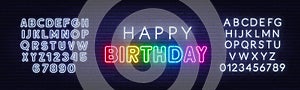 Happy birthday rainbow neon sign on a brick wall.