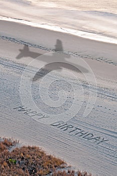 Happy Birthday in the Sand with airplane
