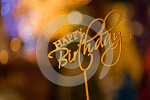 Happy Birthday text sign topper stick on the top of bouquets blurred in bokeh background.