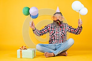 happy birthday to you. bearded mature man celebrate birthday party. cheerful man in bday hat hold holiday balloons