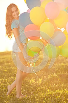 Happy birthday woman against the sky with rainbow-colored air balloons