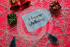 Happy Birthday write on label with Pink backgroud. It means Best Wishes. Frame of Christmas Decoration