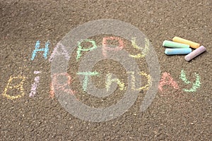 Happy birthday written in colored crayons on the sidewalk