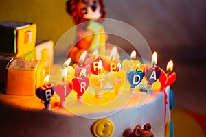 Happy Birthday Written In Lit Candles On Colorful Cake