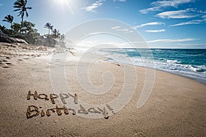Happy Birthday written in the sand