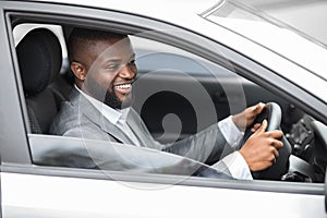 Happy black businessman driving home after working day