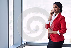 Happy black businesswoman smiling while talking on her mobile cellphone