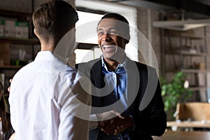 Happy black ceo handshaking rewarding successful worker, employe