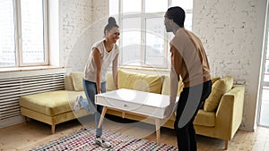 Happy black couple carrying furniture moving to new house