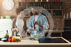 Happy black couple cooking dinner together