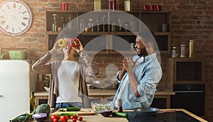 Happy black couple cooking and having fun in kitchen