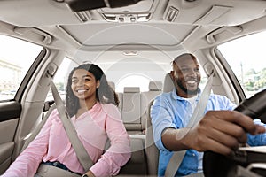 Happy black couple enjoying drive on new car