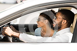 Happy black couple enjoying road trip, sitting in car