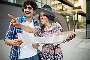 Happy black couple on vacation sightseeing city with map