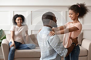 Happy black dad and daughter hug reunited after parting