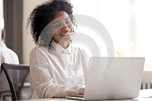 Happy black employee get pleasant message on laptop