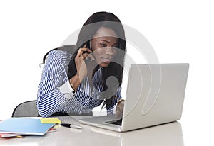 Happy black ethnicity woman working at computer laptop and mobile phone relaxed