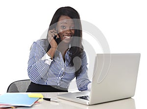 Happy black ethnicity woman working at computer laptop and mobile phone relaxed