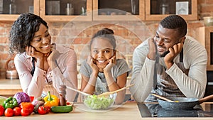 Happy black family cooking healthy dinner together at kitchen