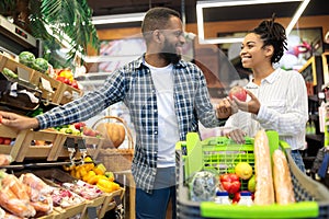 Happy Black Family Couple Buying Vegetables In Supermarket Grocery Shop