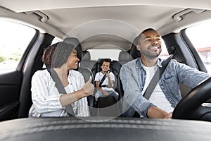 Happy black family enjoying car ride together