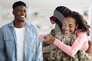 Happy black family greeting mother soldier back from army