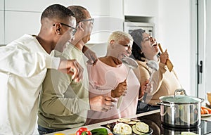 Happy black family having fun cooking together in modern kitchen