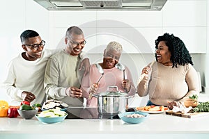 Happy black family having fun cooking together in modern kitchen