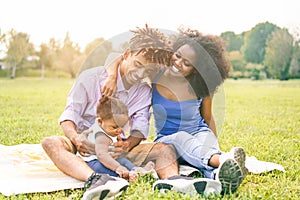 Happy black family having fun doing picnic outdoor - Parents and their daughter enjoying time together in a weekend day - Love