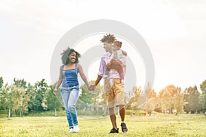 Happy black family having fun doing picnic outdoor - Parents and their daughter enjoying time together in a weekend day - Love