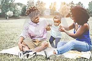 Happy black family having fun doing picnic outdoor - Parents and their daughter enjoying time together in a weekend day - Love