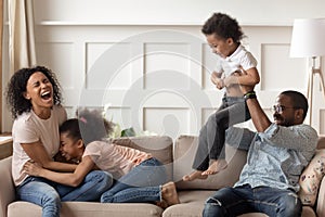 Happy black family having fun playing with children at home
